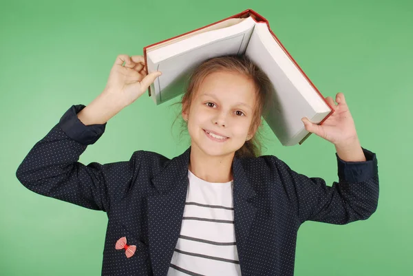 Chica de la escuela joven con libro rojo — Foto de Stock