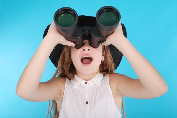 Menina bonita olhando através de binóculos com expressão surpresa — Fotografia de Stock