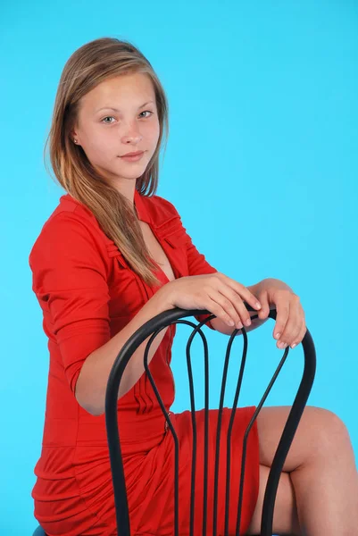 Sonriente chica se sienta en una silla aislada — Foto de Stock