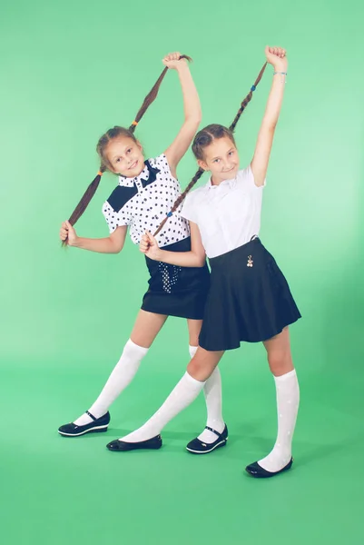 Dos niñas de la escuela juega con el pelo trenzado . —  Fotos de Stock