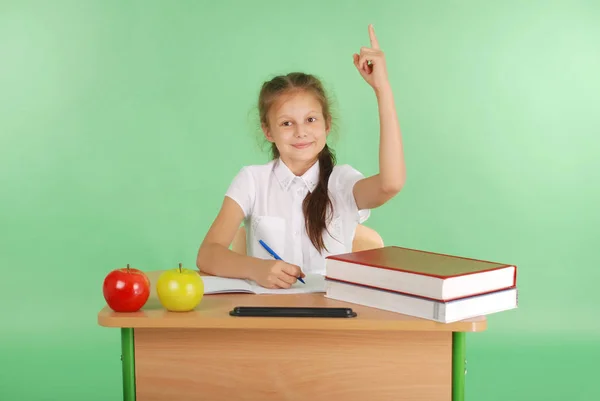Girl in a school uniform raising hand to ask question — Stock Photo, Image