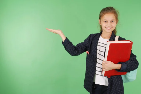 Junges Schulmädchen mit rotem Buch und Rucksack — Stockfoto