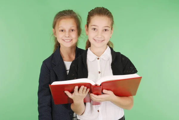 Две школьницы с красной книгой — стоковое фото