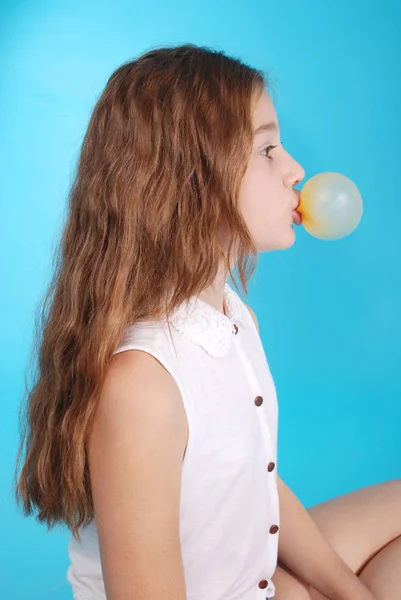 Chica joven haciendo burbuja con goma de mascar — Foto de Stock