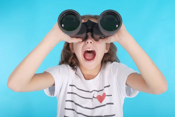 Bella ragazza che guarda attraverso il binocolo con espressione sorpresa — Foto Stock