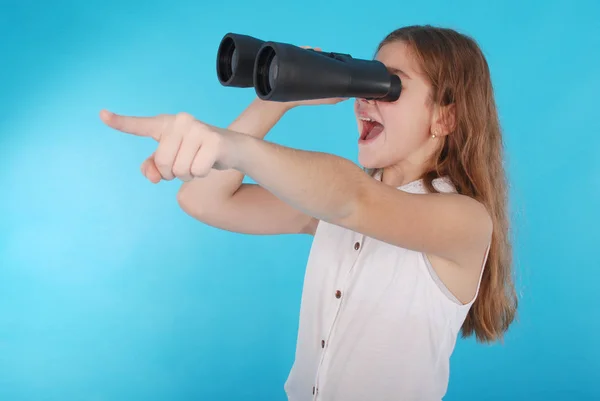 Beautiful young girl  looking through binoculars with surprised expression — Stock Photo, Image