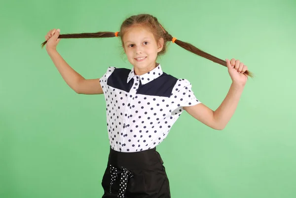 Escola menina brinca com o cabelo entrançado . — Fotografia de Stock