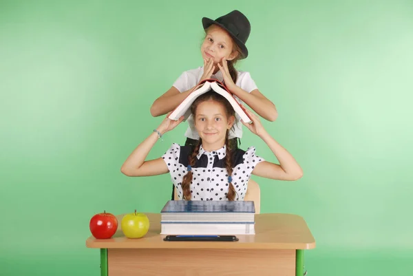 Dva dívka ve školní uniformě, sedí u stolu a čtení knihy — Stock fotografie