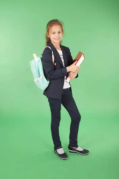 Junges Schulmädchen mit rotem Buch und Rucksack — Stockfoto