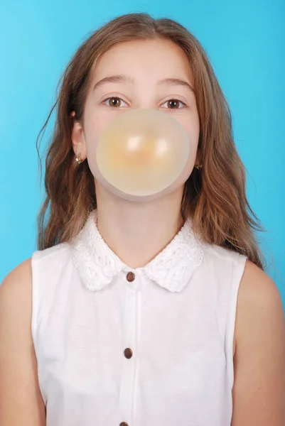 Chica joven haciendo una gran burbuja con un chicle — Foto de Stock