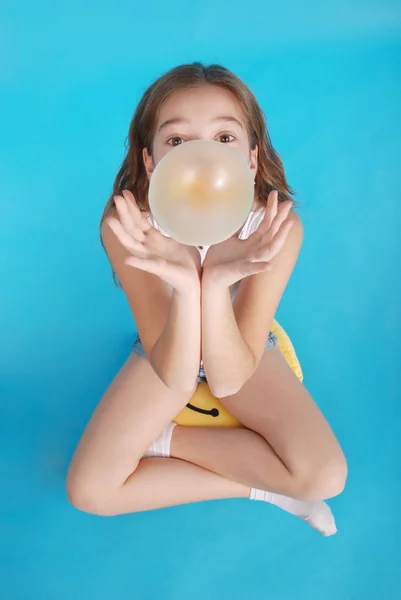 Top view of beautiful young brunette girl blowing bubble gum — Stock Photo, Image