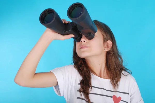 Young girl with binoculars looking up at copy space — Stock Photo, Image