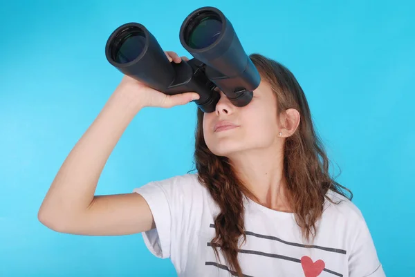 Jeune fille avec des jumelles levant les yeux vers l'espace de copie — Photo