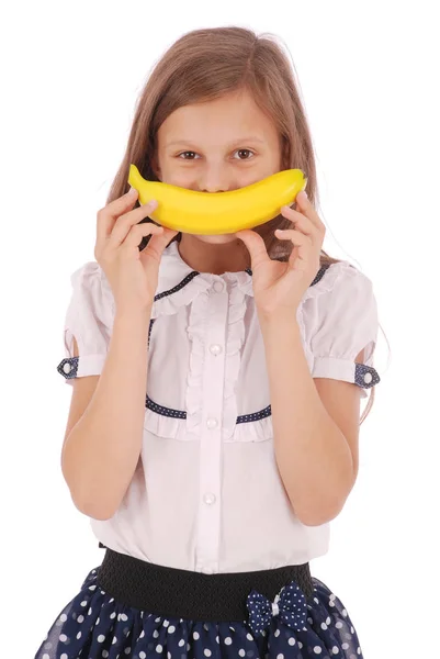 Menina segura uma banana na boca, imitando um sorriso — Fotografia de Stock