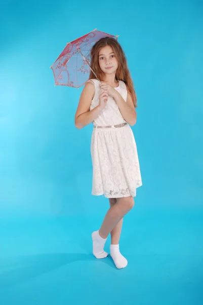 Весела молода дівчина в білій сукні з парасолькою — стокове фото