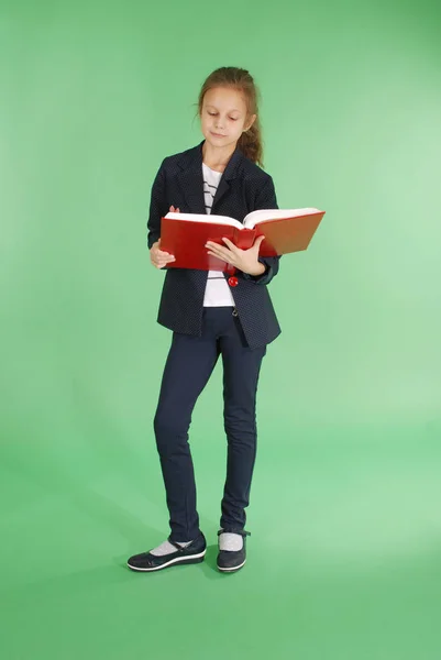 Jovem menina da escola com livro vermelho — Fotografia de Stock