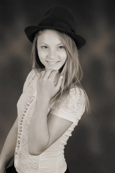 Beautiful young girl in black hat on his head — Stock Photo, Image