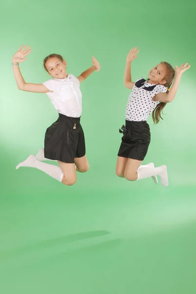Cute happy school girls jumping — Stock Photo, Image
