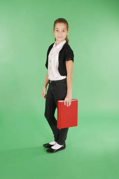 Chica de la escuela joven con libro rojo —  Fotos de Stock