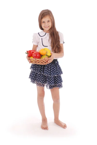 Menina sorridente segurando cesta de palha com frutas — Fotografia de Stock