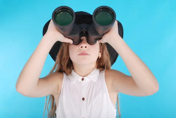 Young girl with binoculars looking up at copy space — Stock Photo, Image