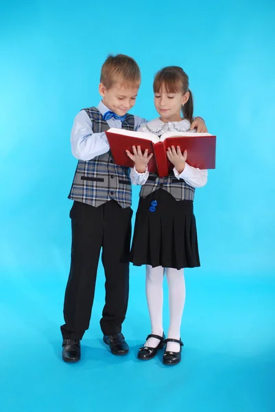 Chlapec a dívka ve školní uniformě čtení knihy — Stock fotografie