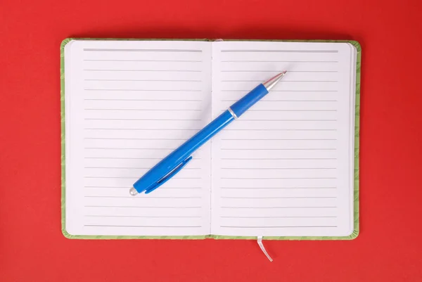 Caderno branco e caneta azul — Fotografia de Stock