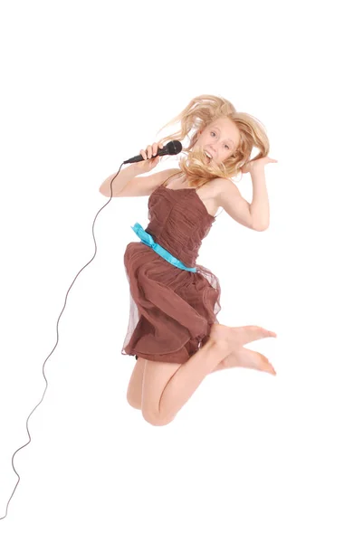 Gelukkig jonge prachtige tienermeisje springen en zingen met micr — Stockfoto