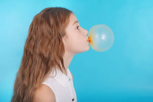 Young girl doing bubble with chewing gum