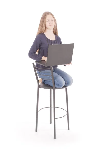 Meisje zit op een stoel en het houden van een laptopcomputer — Stockfoto