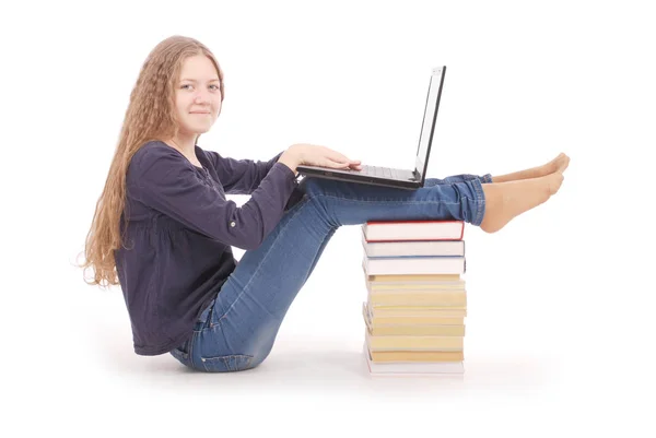 Schülerin sitzt mit Laptop seitlich auf dem Buch — Stockfoto