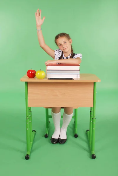 Fille dans un uniforme scolaire levant la main pour poser la question — Photo