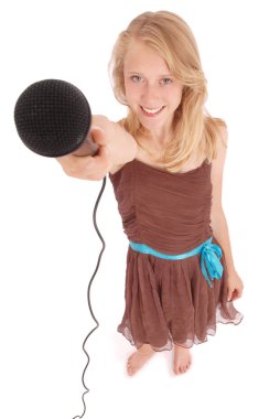 Bir mikrofon önünde tutan genç kız