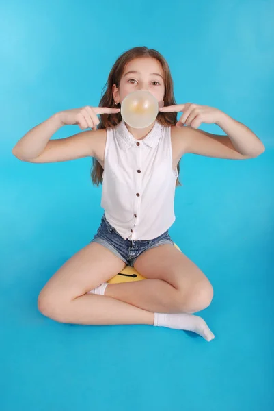 Fille soufflant une grande bulle de gomme à bulle — Photo