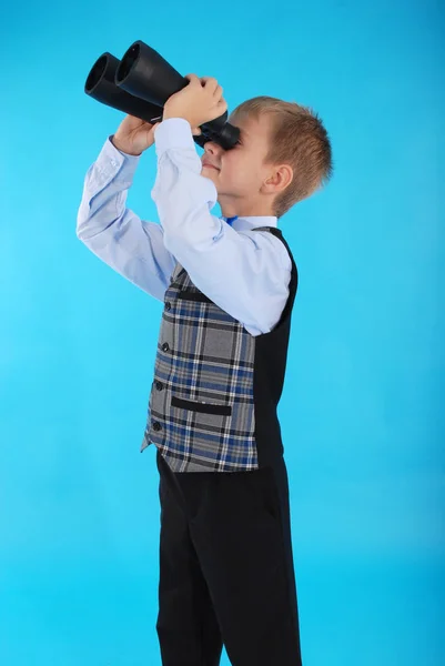 Schoolboy looking through binoculars — Stock Photo, Image