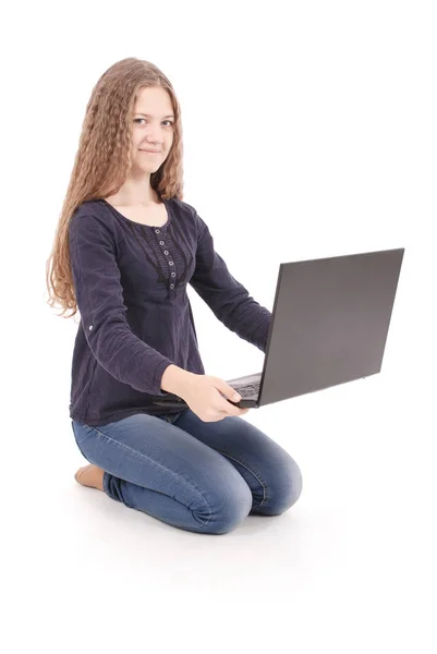 Student teenage girl sitting sideways on the floor with laptop — Stock Photo, Image