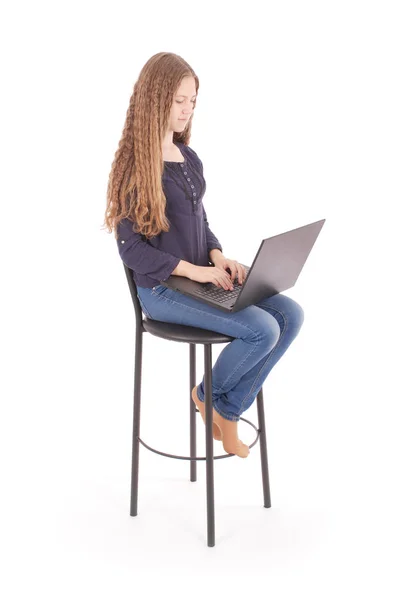 Dziewczyna siedzi na krześle, a trzymając komputer przenośny — Zdjęcie stockowe