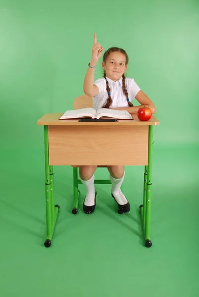 Meisje in een schooluniform verhogen hand vraag — Stockfoto