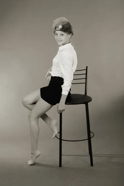 Menina jovem senta-se em uma cadeira — Fotografia de Stock