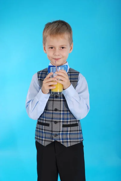 Хлопчик п'є апельсиновий сік — стокове фото
