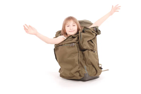 La bambina guarda fuori da un grande zaino turistico — Foto Stock