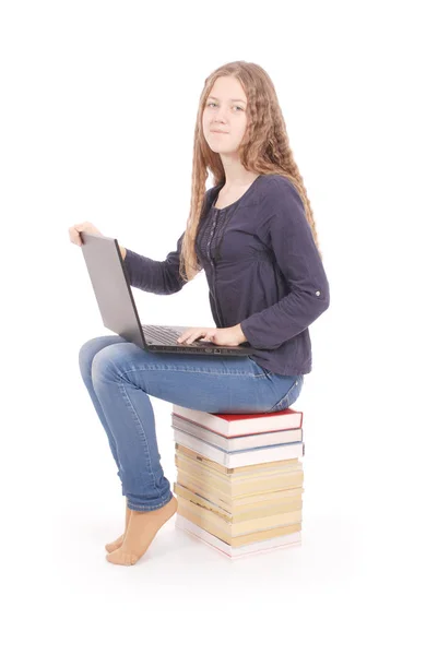 Student teenage girl sitting sideways on the book with laptop — Stock Photo, Image