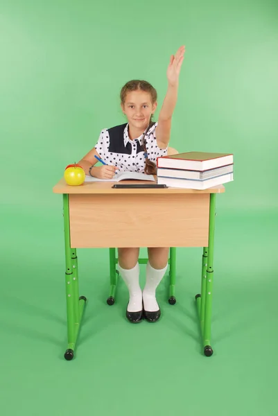 Meisje in een schooluniform verhogen hand vraag — Stockfoto