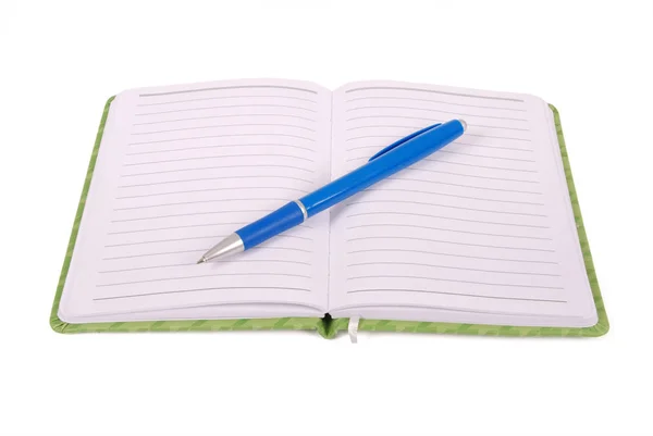 Groene notebook en blauwe pen — Stockfoto