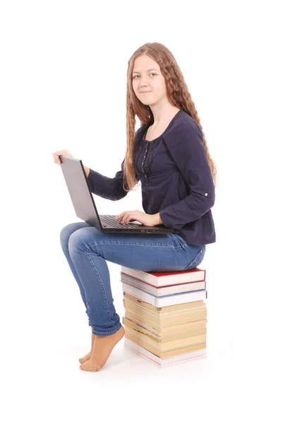学生少女侧身坐在这本书上的笔记本电脑 — 图库照片