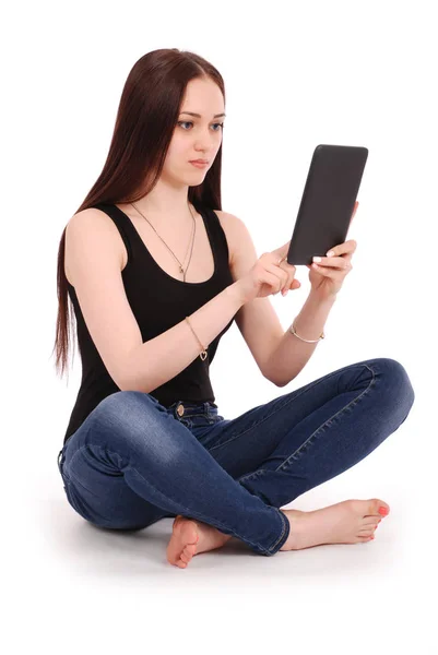 Student teenage girl sitting sideways on the floor with tablet p — Stock Photo, Image