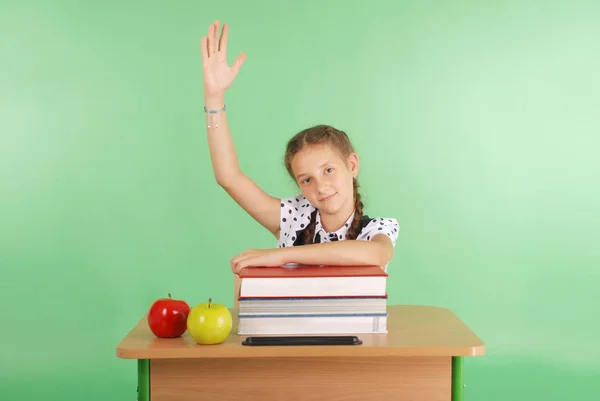 Girl in a school uniform raising hand to ask question — Stock Photo, Image
