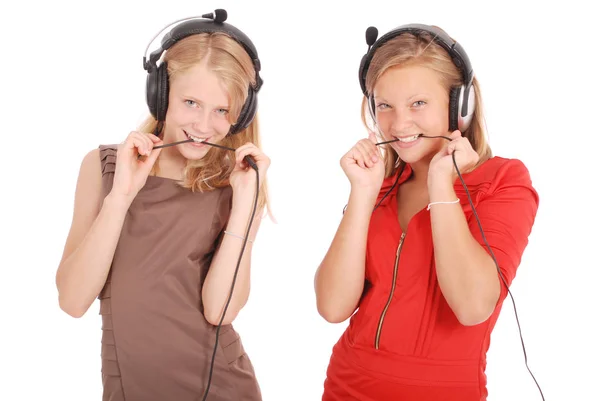 Dos chicas adolescentes bonitas escuchando música en sus auriculares — Foto de Stock