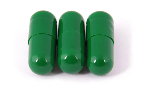 Drie capsule pillen met groene kleur — Stockfoto