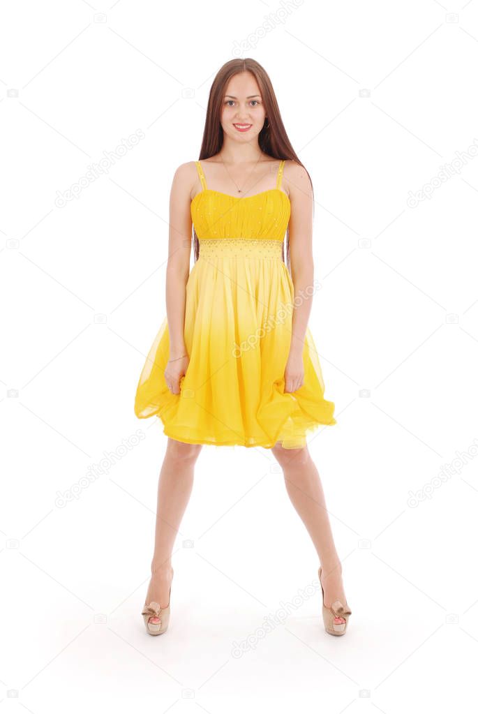 Teenage girl is standing back yellow dress.